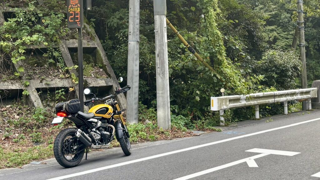 気温表示の電光掲示板の前に駐車するトライアンフスクランブラー400XC